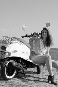 poserende vrouw op retro scooter Brommeleute