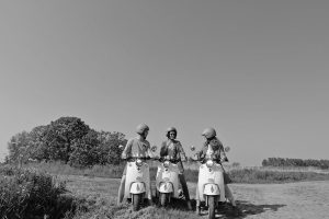 vrienden op retro scooters bocht