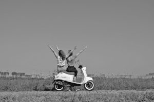 lachende zussen op retro scooters Eede